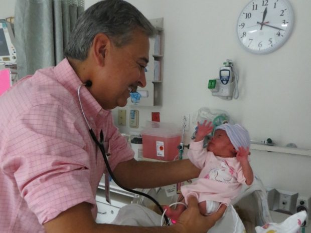 Dr. Bob Castro holding an infant in the Salinas NICU.